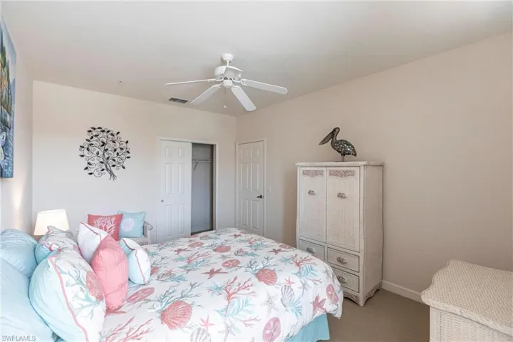 Carpeted bedroom with a ceiling fan and a closet