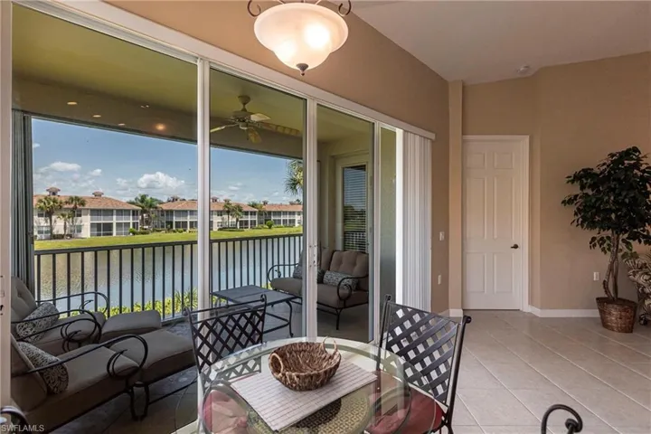 Sunroom featuring tile patterned floors and a water view