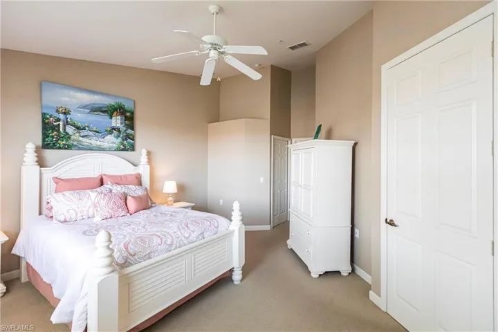 Bedroom with light carpet and a ceiling fan