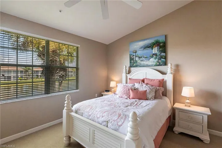 Carpeted bedroom with lofted ceiling and a ceiling fan