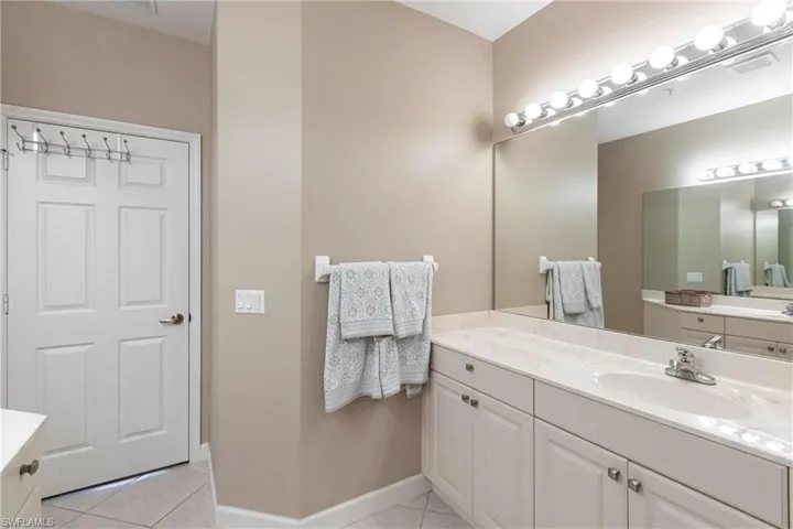 Full bathroom featuring light tile patterned floors and vanity