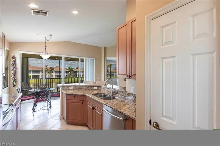 Kitchen featuring decorative light fixtures, light stone counters, a peninsula, recessed lighting, and stainless steel appliances
