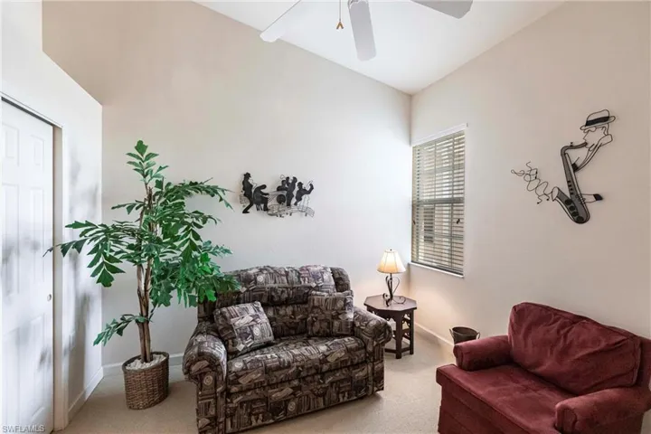 Carpeted living room with baseboards and a ceiling fan