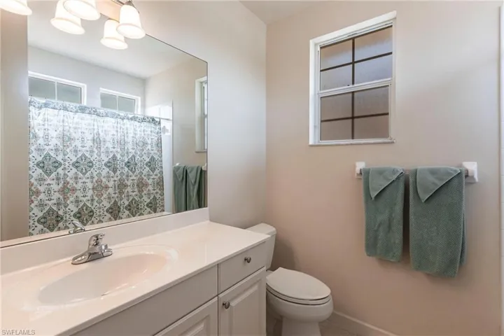 Bathroom with vanity, curtained shower, and light tile patterned floors