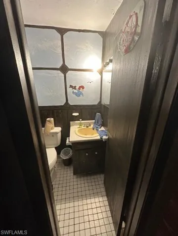 Bathroom featuring vanity, wood walls, and tile patterned floors