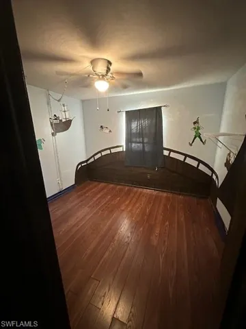 Unfurnished living room featuring a ceiling fan and wood finished floors