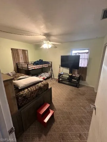 Carpeted bedroom with a textured ceiling and a ceiling fan