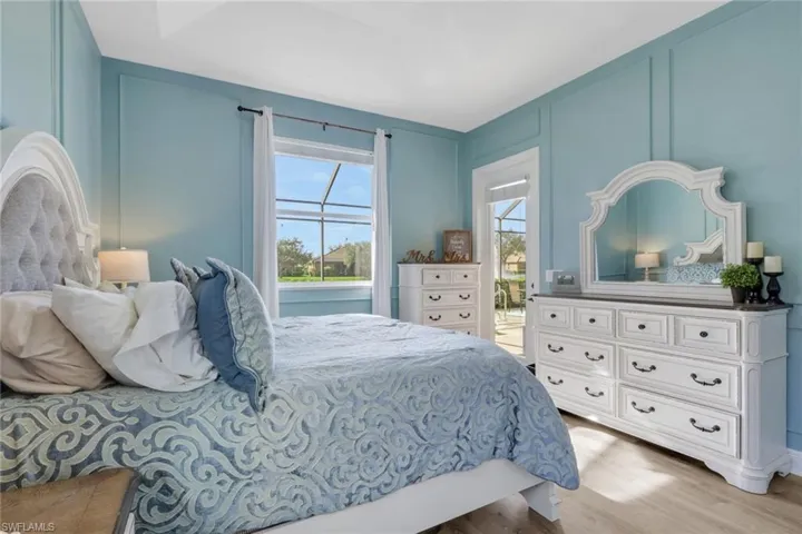 Bedroom featuring a decorative wall, light wood-type flooring, and access to exterior