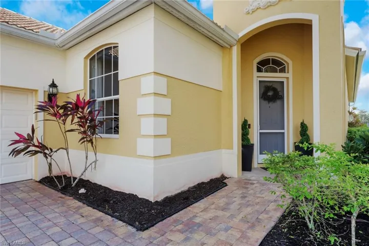 Entrance to property featuring stucco siding, a garage, and a tiled roof