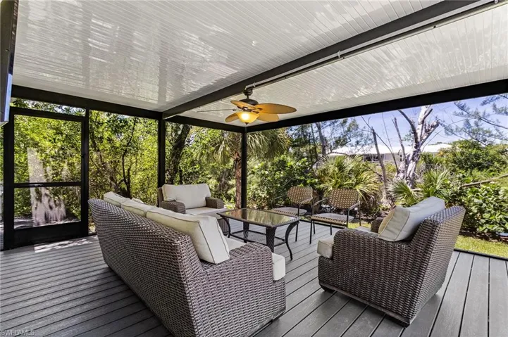 Sunroom / solarium with an outdoor hangout area, a wooden deck, and ceiling fan
