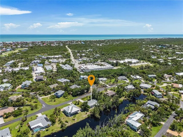 Aerial view of residential area with a large body of water and a tree filled landscape