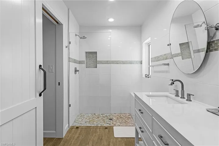 Full bathroom featuring a stall shower, vanity, dark wood-style floors, and recessed lighting
