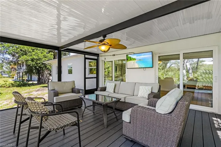 Sunroom / solarium featuring an outdoor living space, a ceiling fan, a deck, and beamed ceiling