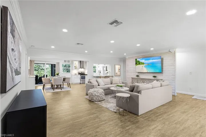 Living room featuring ornamental molding, light wood finished floors, and recessed lighting