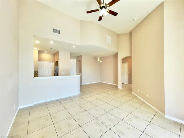Spare room with recessed lighting, ceiling fan, arched walkways, light tile patterned floors, and a high ceiling