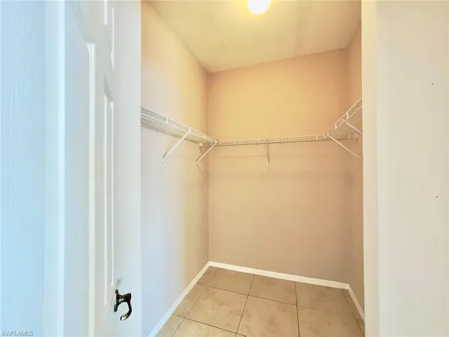 Walk in closet with light tile patterned floors