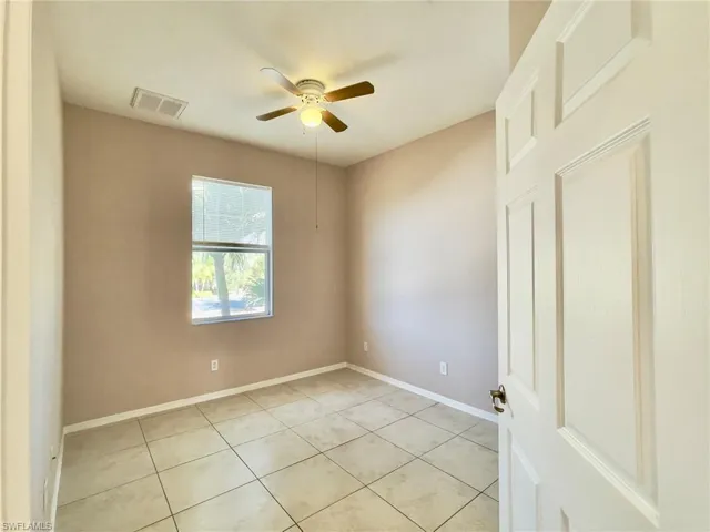 Unfurnished room with a ceiling fan and light tile patterned flooring