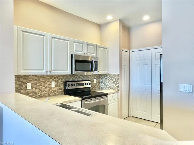 Kitchen featuring stainless steel appliances, tasteful backsplash, and recessed lighting