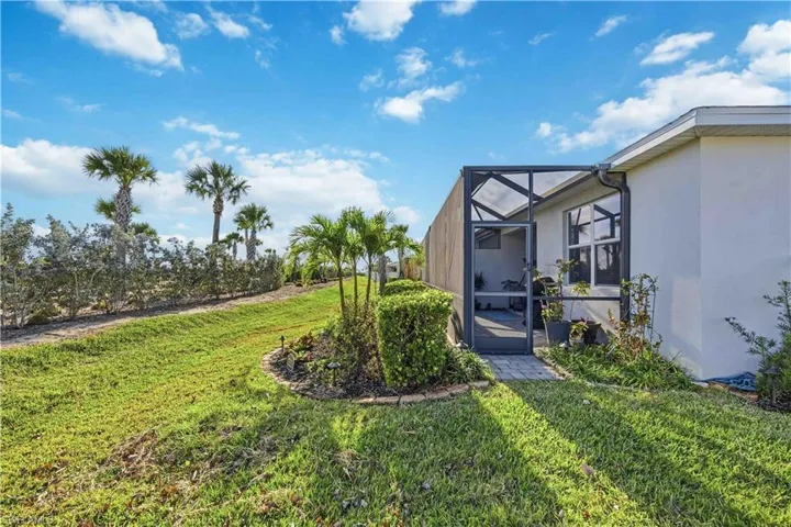 View of green lawn featuring glass enclosure and a sunroom