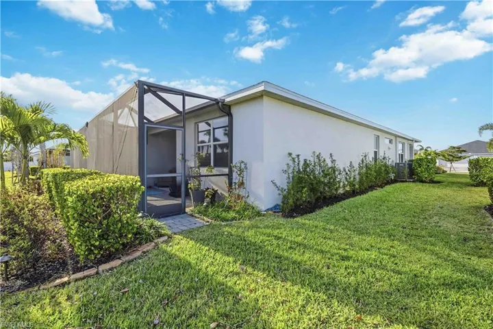 View of home's exterior featuring stucco siding, a sunroom, a lawn, and a lanai