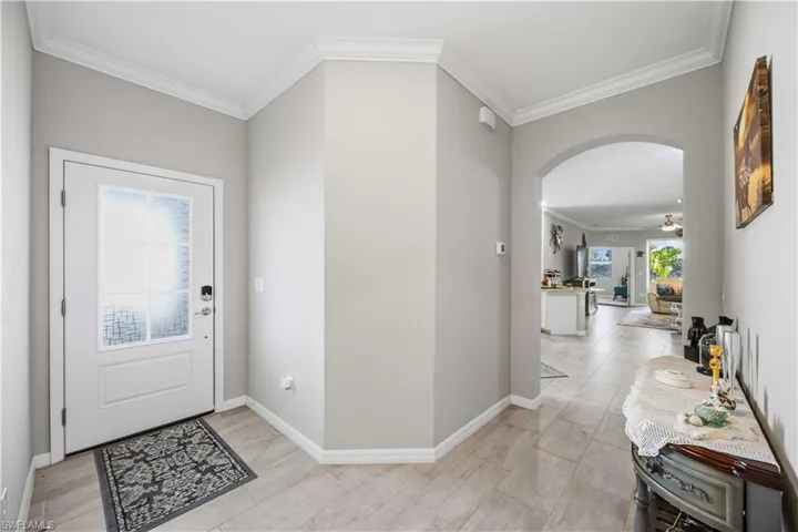 Foyer with crown molding and arched walkways