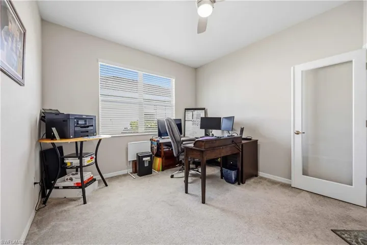 Home office featuring light colored carpet and ceiling fan