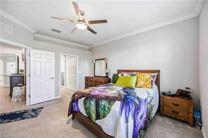 Bedroom featuring crown molding, light colored carpet, ceiling fan, and a closet