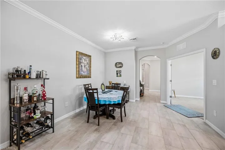 Dining area featuring arched walkways and crown molding