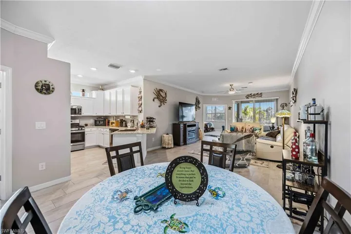 Dining space with ornamental molding, ceiling fan, and recessed lighting