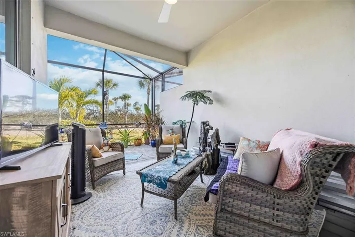 Sunroom / solarium with an outdoor living space, ceiling fan, a patio area, and vaulted ceiling