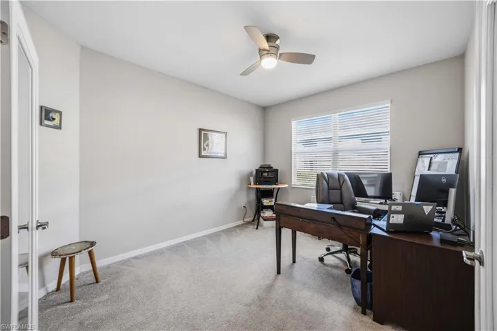Home office featuring light carpet and ceiling fan