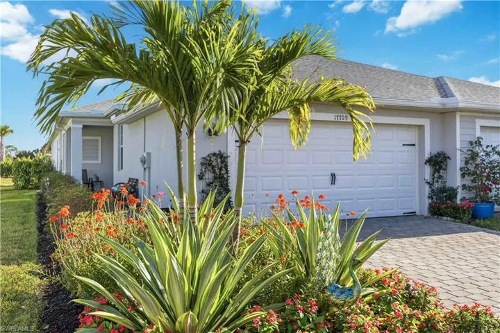 View of side of property with stucco siding, a garage, decorative driveway, and a shingled roof
