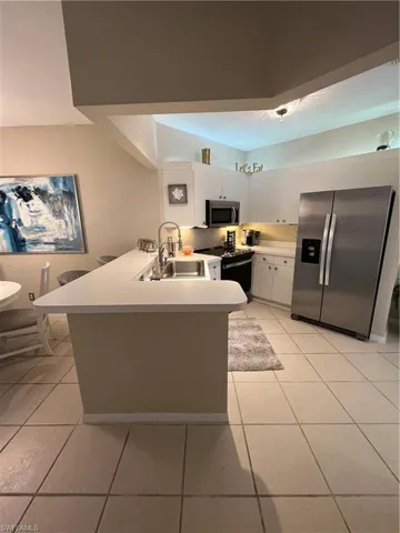 Kitchen featuring light-toned tile flooring and white cabinetry