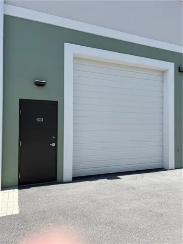 View of garage door and passage door from exterior.