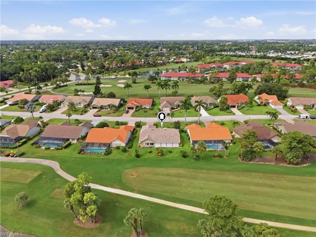 Aerial perspective showcasing a residential community with abundant greenery and golf course access