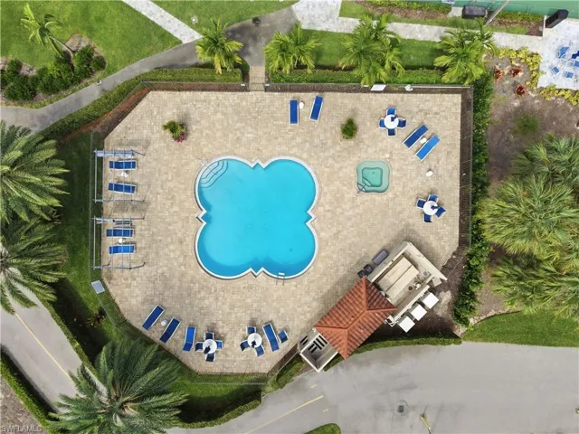 Clover-shaped pool with integrated steps, surrounded by a paver deck