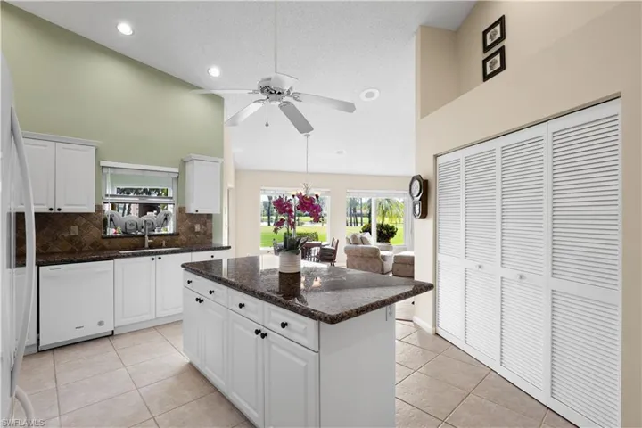 Kitchen featuring white cabinetry, granite countertops, and tile flooring