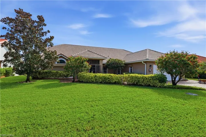 Single-story residence featuring a tile roof, stucco exterior, and an arched window