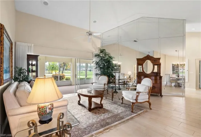 Vaulted ceilings with recessed lighting, wood-finish flooring, a full mirrored wall, and sliding glass doors opening to the outdoors