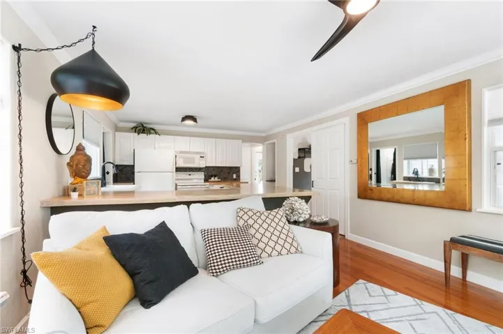 Living room featuring ornamental molding, light wood-type flooring, and sink