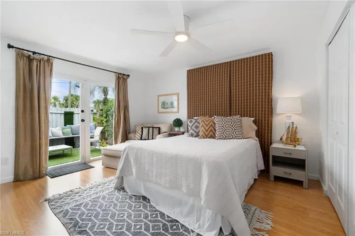 Bedroom featuring multiple windows, light hardwood / wood-style floors, and access to outside