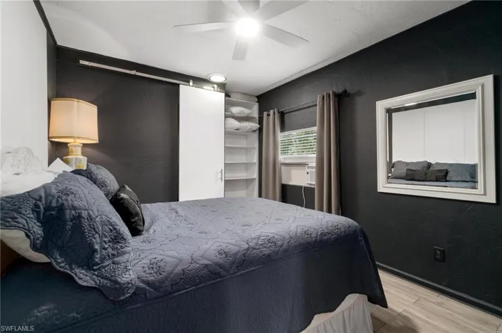 Bedroom featuring a walk in closet, ceiling fan, and light hardwood / wood-style flooring