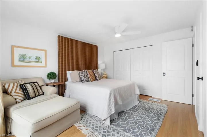 Bedroom with hardwood / wood-style floors, a closet, and ceiling fan