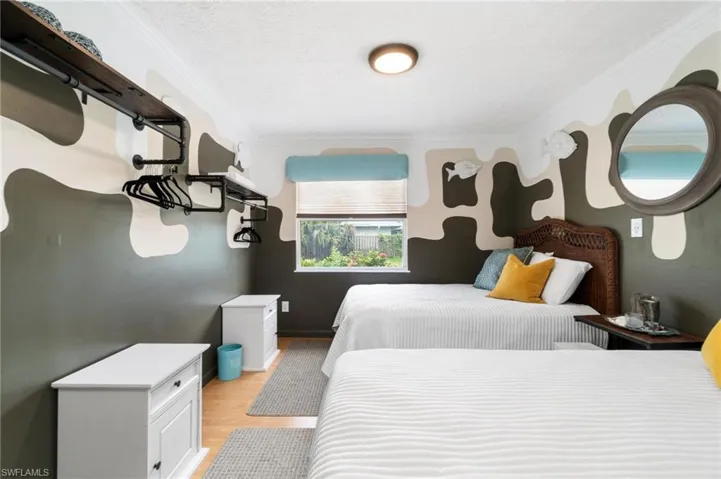 Bedroom with light hardwood / wood-style flooring, a textured ceiling, and crown molding
