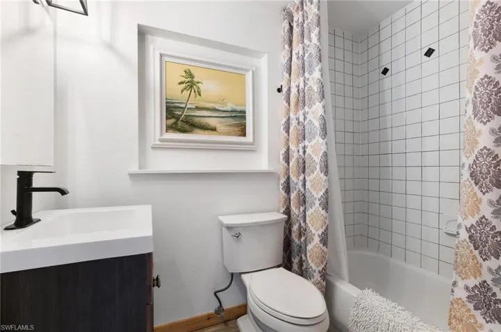 Full bathroom featuring shower / tub combo, vanity, and toilet