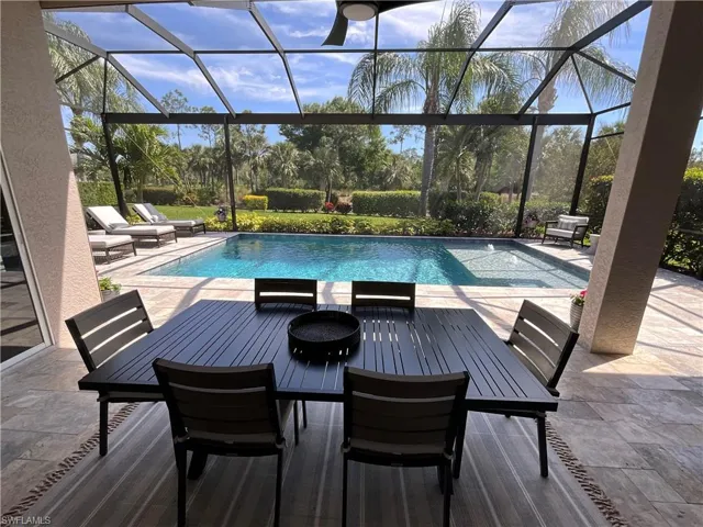 Outdoor pool with outdoor dining space, a patio area, and a lanai