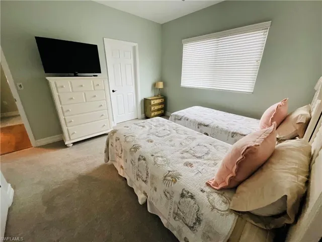 Carpeted bedroom featuring baseboards