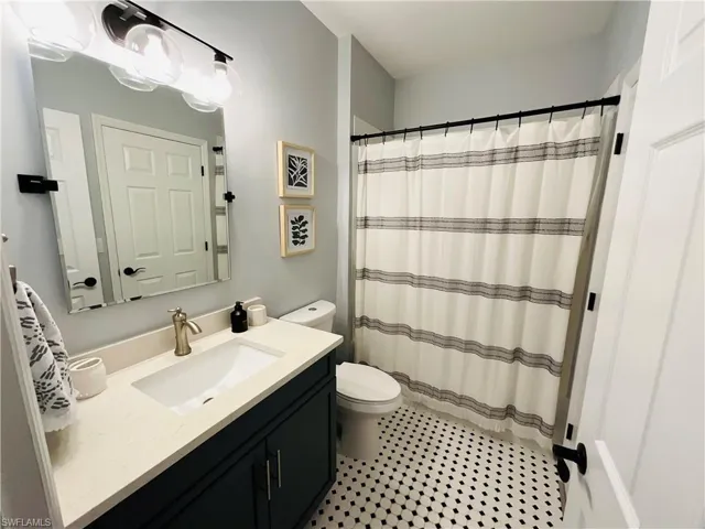 Remodeled Guest Bathroom featuring curtained shower, vanity, and toilet