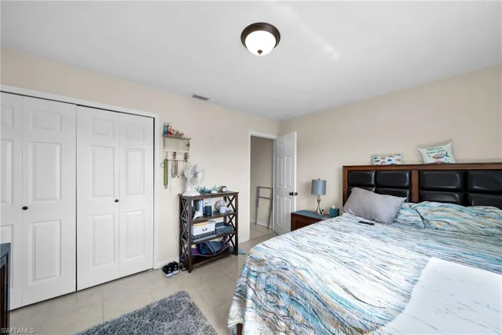 Bedroom featuring light tile patterned floors and a closet