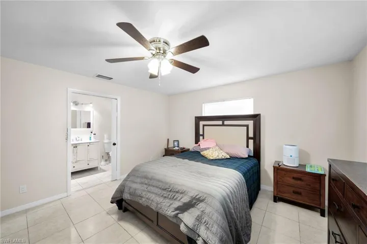 Tiled bedroom with ensuite bathroom and ceiling fan
